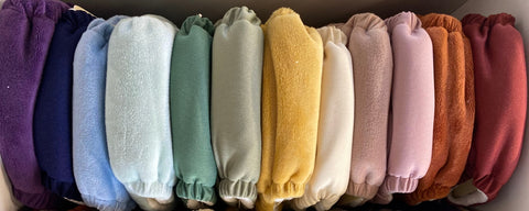 a pleasing array of soft all-in-one cloth diapers organized in a rainbow from dark, cool colors to light, warm colors