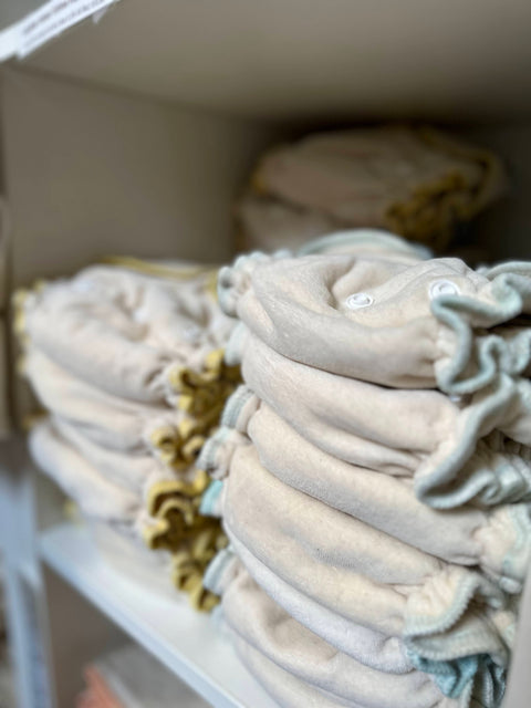 two neat stacks of soft fitted diapers in a cubby